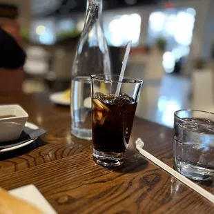 a glass of soda and a sandwich on a table