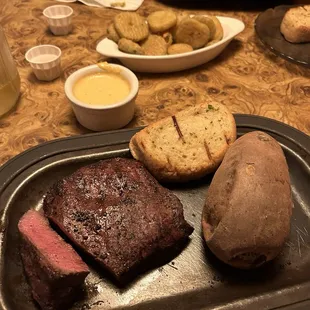 10 oz flat iron medium rare with baked sweet potato. Fried pickles in the background.