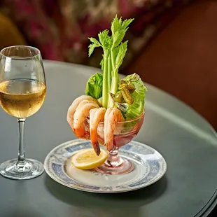 a glass of wine and a shrimp cocktail