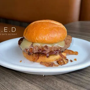 1/2 Bison Burger on a Brioche Bun with Aged White Cheddar, Fried Onions, and Bourbon Ketchup