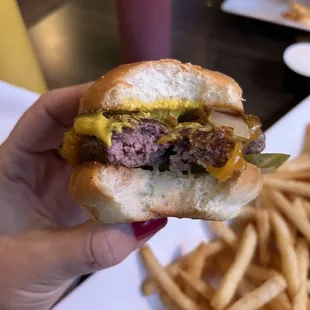 a hand holding a hamburger