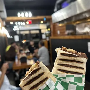 a person holding a sandwich