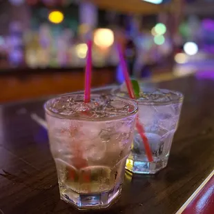 two glasses of alcohol on a bar