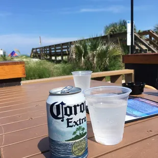 a can of corona extra next to a glass of water
