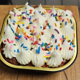 a cake with white frosting and sprinkles