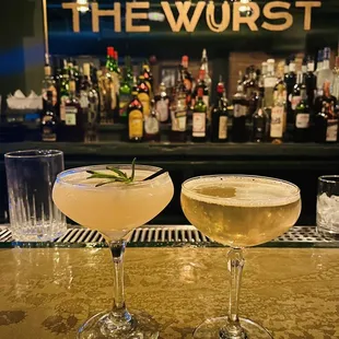 two glasses of wine on a bar