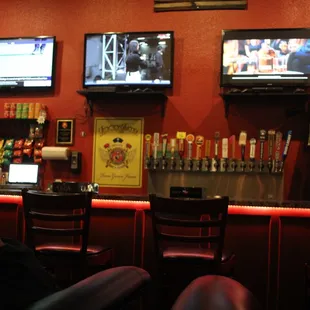 a man sitting at the bar watching tvs