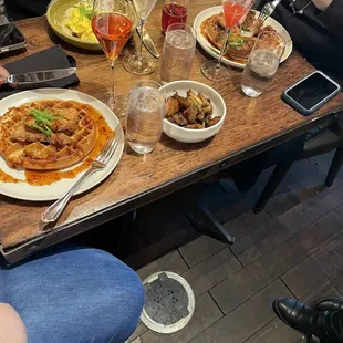 a group of people sitting at a table with plates of food