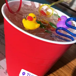 a red cup with rubber ducks in it