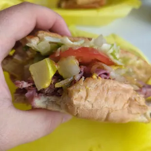 Pastrami sub with grilled onions mustard pickles lettuce and tomato