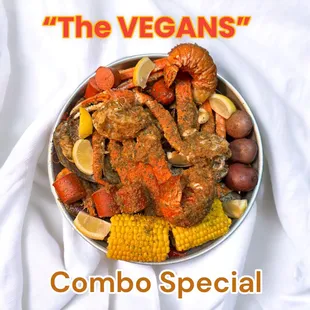 a bowl of crab legs, corn, potatoes, corn on the cob, potatoes, and corn on the