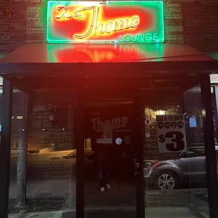 the front of a restaurant with a neon sign