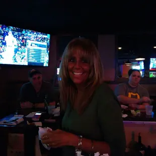 a woman smiling in a sports bar