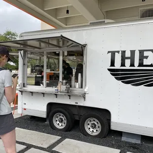 a woman standing in front of a food truck
