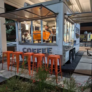 a food truck with orange stools