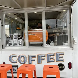 orange stools in front of a coffee truck