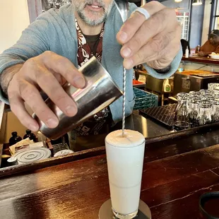 a man pouring a drink at a bar