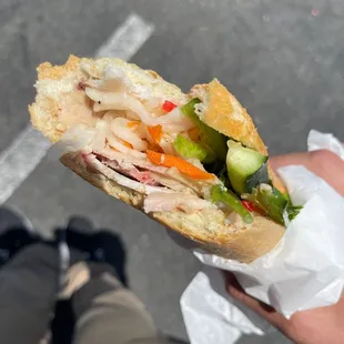 a person holding a sandwich