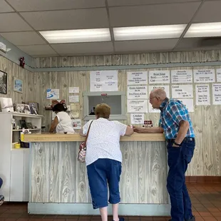 The order, and pay as you enter counter with the menu options on the wall.