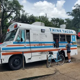 a man standing next to a food truck