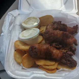 Beer battered fish and chips with tartar sauce and coleslaw.