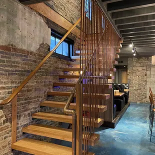Obsessed with this custom stairway heading to the upstairs seating/bar