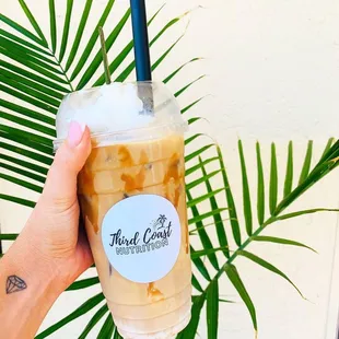a hand holding a cup of iced coffee