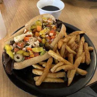 Italian beef sandwich, fries and au jus.
