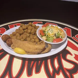 a plate of fried chicken and a side salad