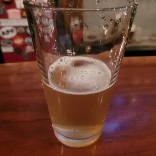 a glass of beer on a bar