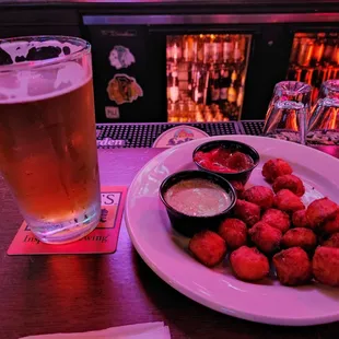 a plate of chicken nuggies and a glass of beer