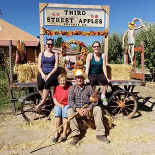 three people sitting in a wagon