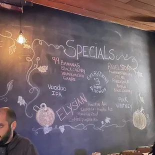 a man sitting at a table in front of a chalk board