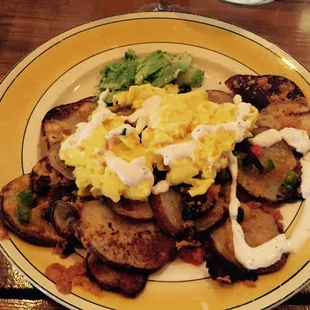 Breakfast Nachos w/ thinly sliced potatoes, scrambled eggs, peppers, cheese, sour cream and avocado.