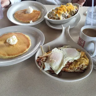 a breakfast of pancakes, eggs, hash browns, and coffee