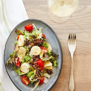 a plate of salad and a glass of wine