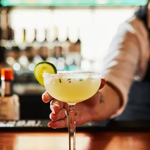 a bartender holding a margarita