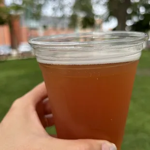 a hand holding a cup of beer
