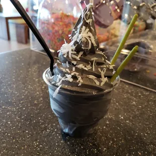 Charcoal Vanilla soft serve with coconut flakes and matcha pocky