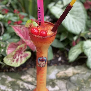 The Local Local favorite Mangonada Margarita with chili stick,Lucas rim and two cherry bombs!!