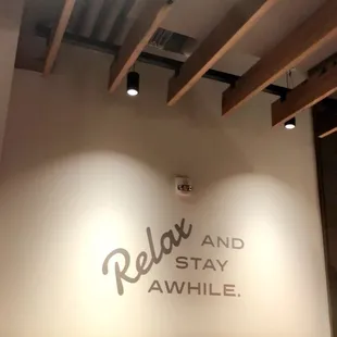 relax and stay awhile sign on the wall