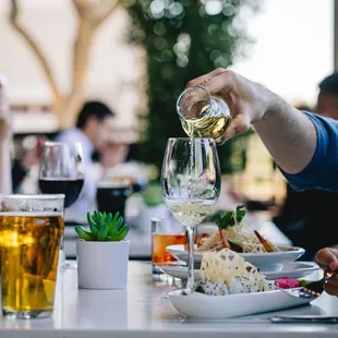 a man pouring white wine into a glass