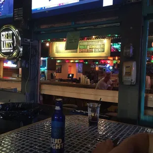 a man sitting at a bar with a beer in front of him