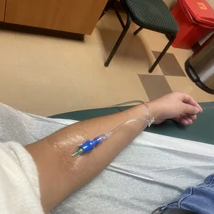 a person in a hospital bed with a tube attached to their arm