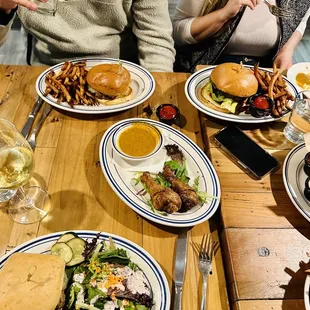 a group of people sitting at a table with plates of food