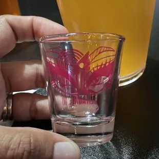 a hand holding a shot glass