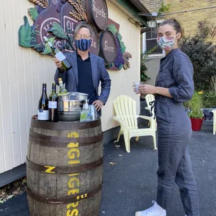 a man and woman standing in front of a barrel