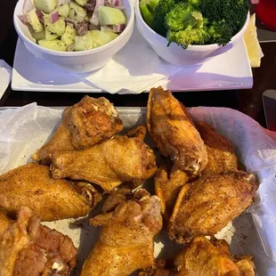 Blackened wings, side cucumer salad, and side of broccoli.