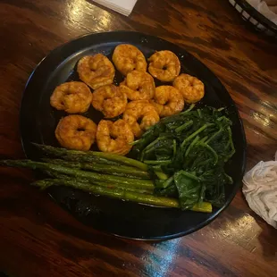 a plate of shrimp, asparagus, and broccoli