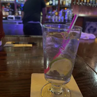a glass of water with a straw and a lime slice